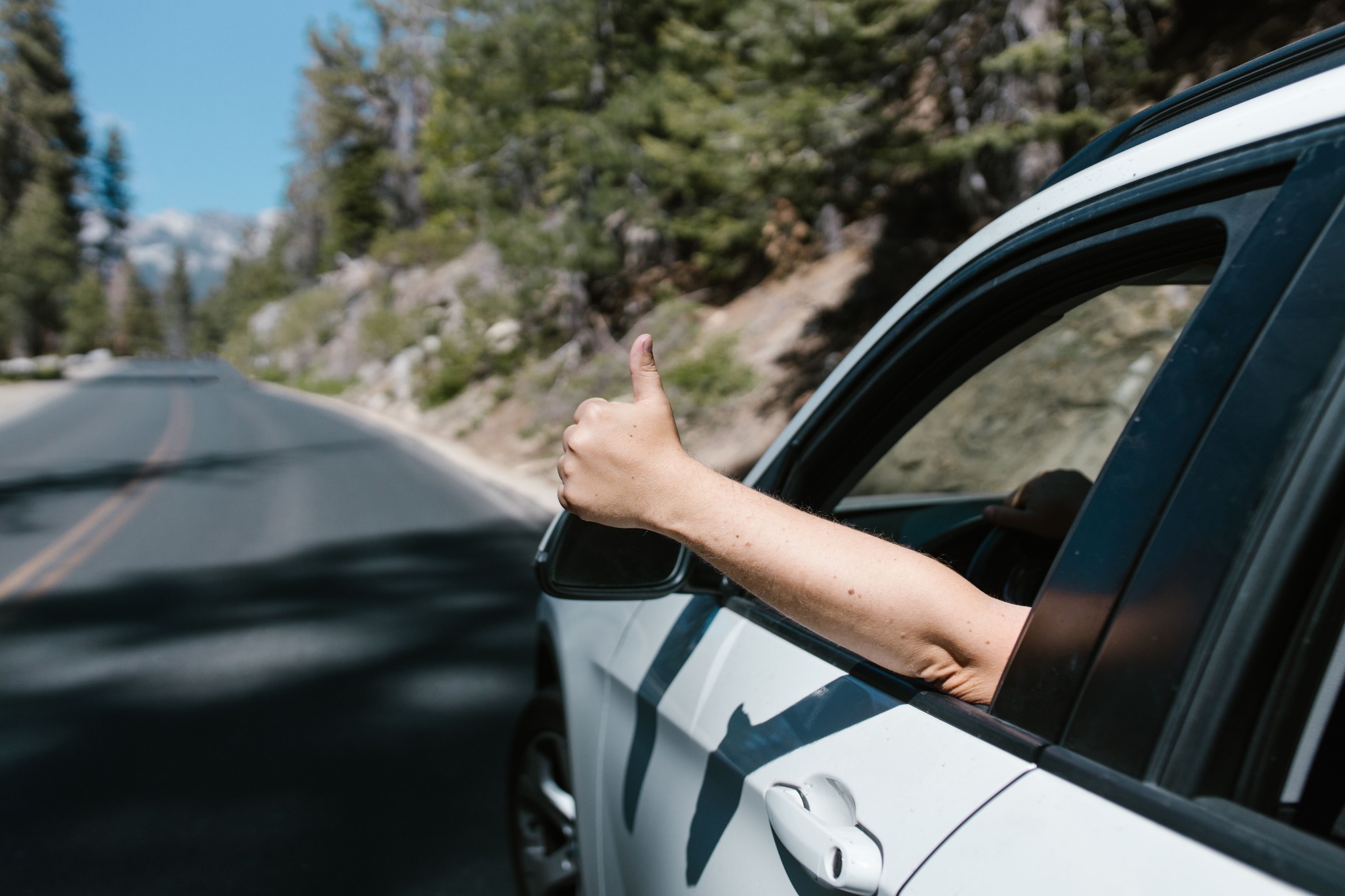 Driver giving a thumbs-up on the road